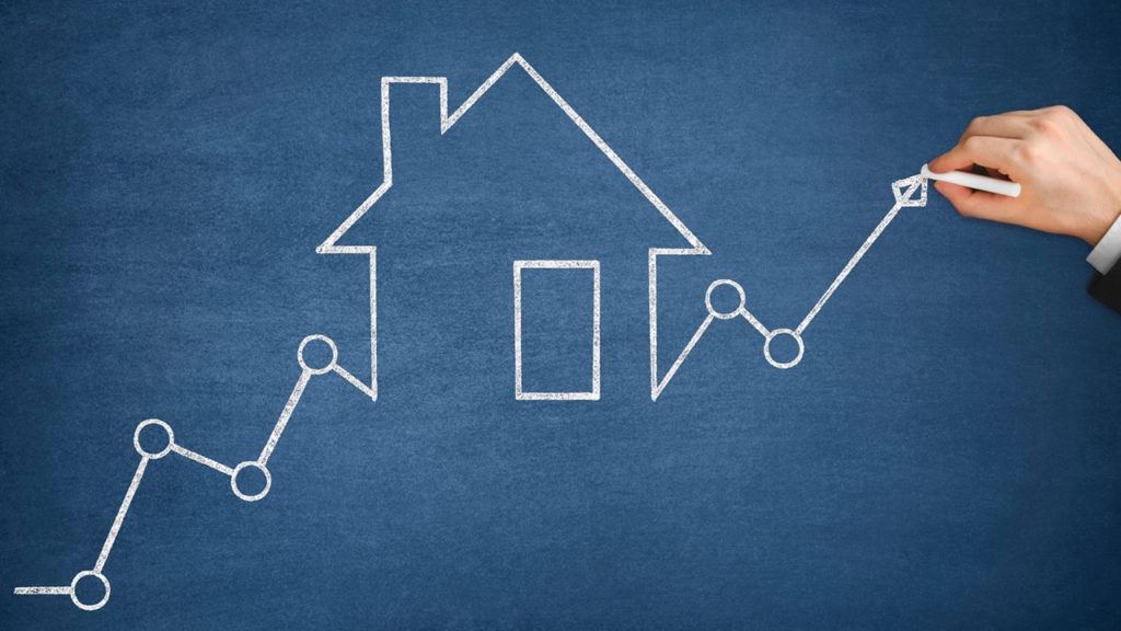 A graph drawn on board with chalk and real estate drawing in centre