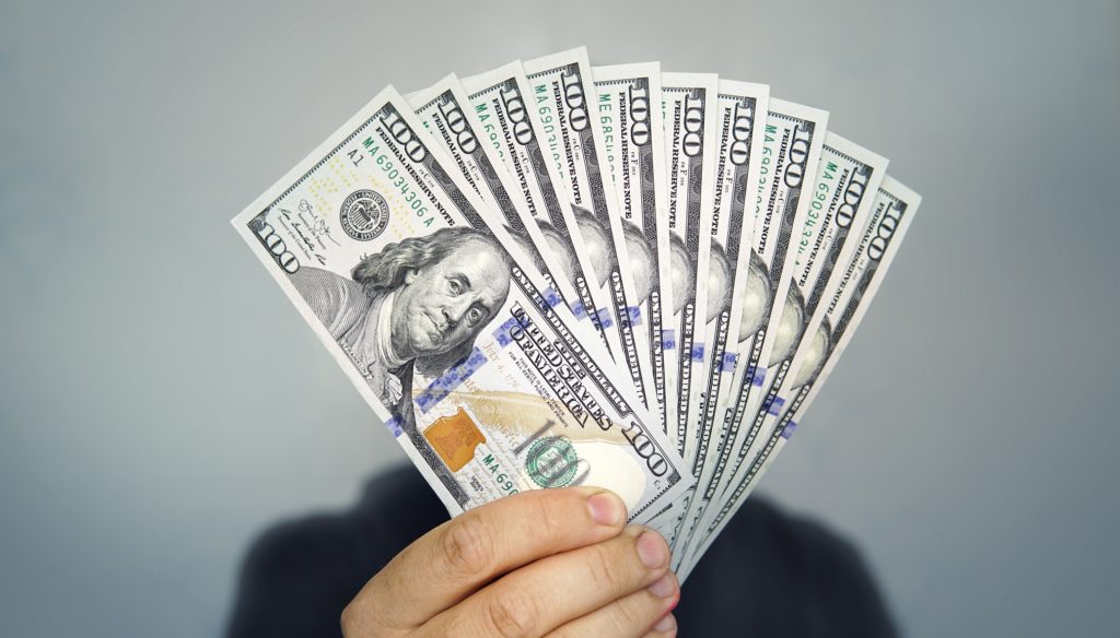 A man showing $100 dollar notes