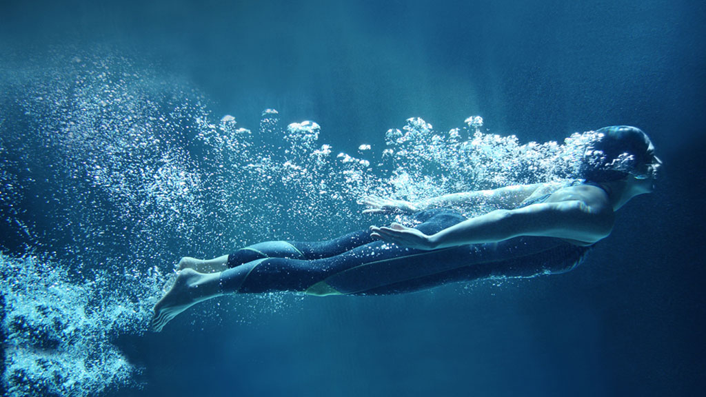 A girl swimming in still blue water