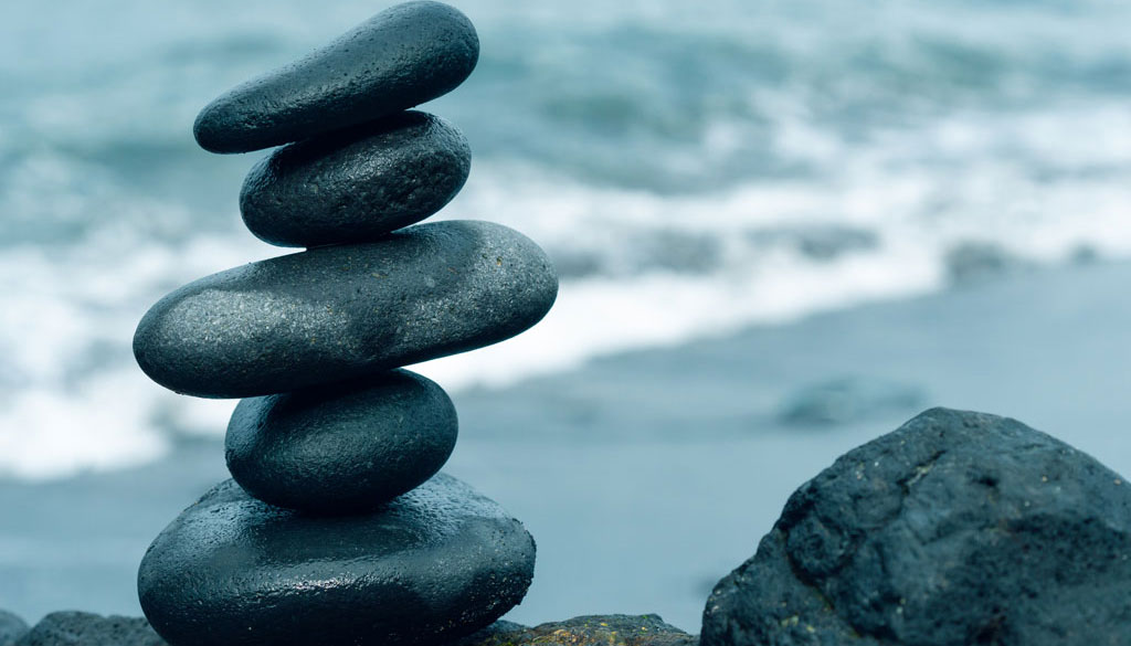 A stack of black stones with sea background