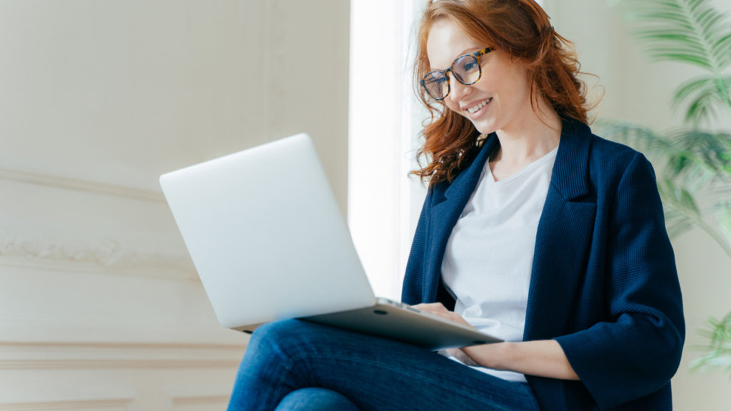 A girl working on her laptop while sitting crossed leg