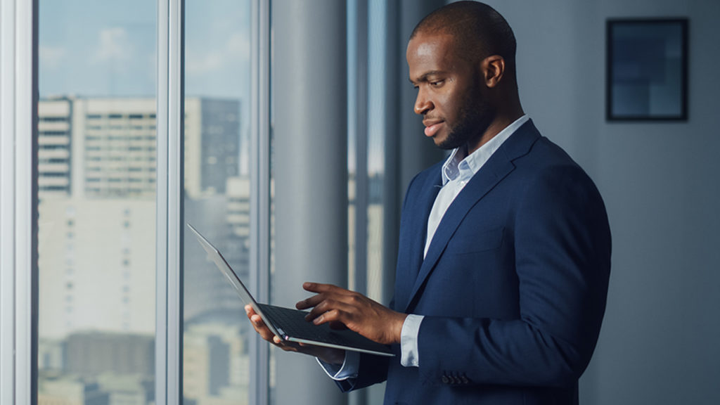 A man in blue suit working on his laptop