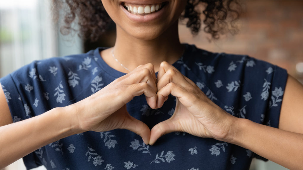 A girl making heart shape with her hand to show love