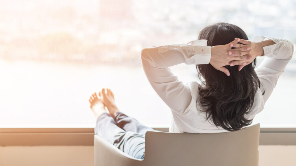 A girl relaxing on chair and looking outside window