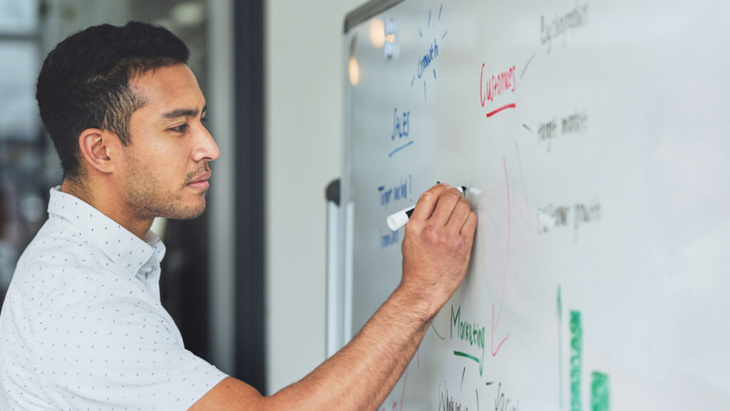 A man writing on white board